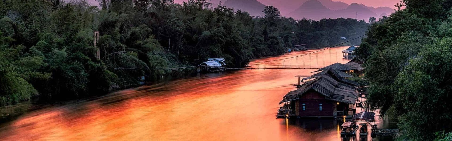Iconic Bridge over the River Kwai in Kanchanaburi on a scenic Kanchanaburi Travel banner by Legend Travel Group.